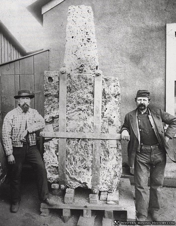 Miners pose by a three-ton piece of malachite and azurite from the Copper Queen Mine. The specimen was displayed at the Chicago World's Fair of 1893