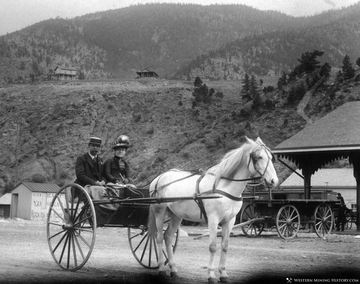 Couple travels by carriage at the railroad depot in Idaho Springs, Colorado ca. 1890s